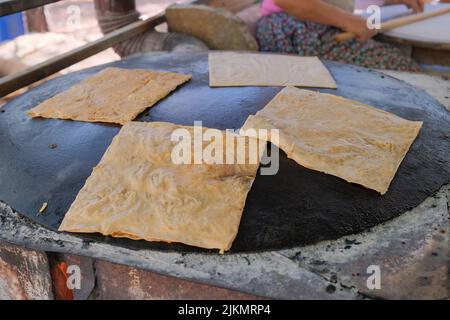 Delicious traditional Turkish dish gozleme on frying pan top outdoors Stock Photo