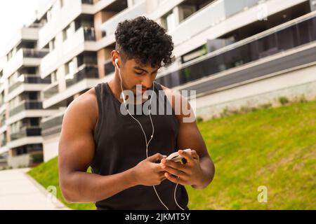 Arab young man doing sports in the city, preparing the music before training Stock Photo