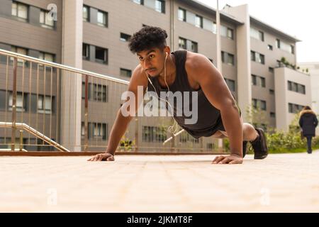 Arab strong young man doing sports in the city, doing some push-ups Stock Photo