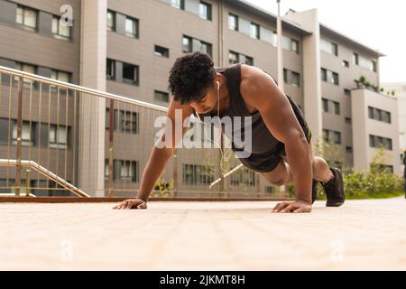Arab strong young man doing sports in the city, doing some push-ups Stock Photo