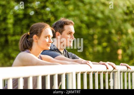 Young woman and man doing stretching exercises in nature Stock Photo