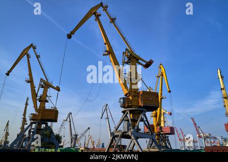 silhouette of port cranes against the backdrop of sunset. Stock Photo
