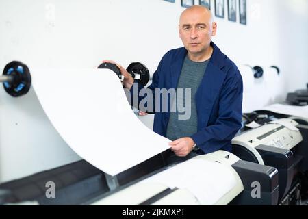 Man working in publishing facility Stock Photo