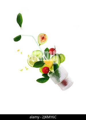 A vertical shot of cocktail ingedents (lime, pig, cherry, cocumbers) falling into a glass isolated on white background Stock Photo