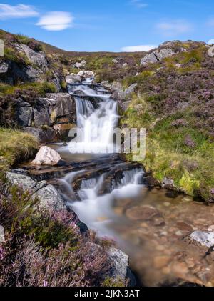 A vertical shot of Falls of Glas Allt leading into Loch Muick in Cairngorms, Scotland Stock Photo