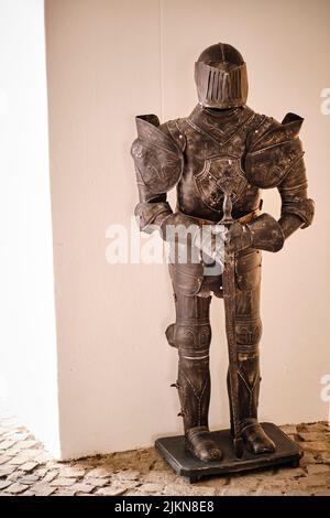 A vertical shot of an iron Knight armor sculpture in a building in Romania Stock Photo