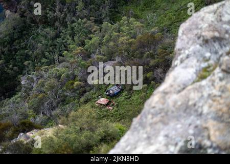 A top view of old abandoned cars been left on the blue mountain covered with green nature in Lincoln's Rock, Australia Stock Photo
