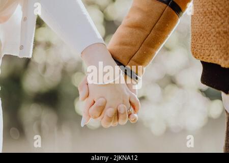 A shallow focus close-up of couple's hands holding Stock Photo