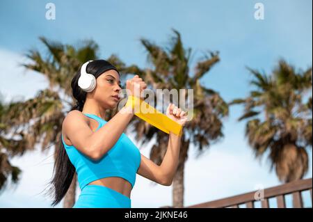 A pretty African American woman doing sports by the beach on a sunny day Stock Photo