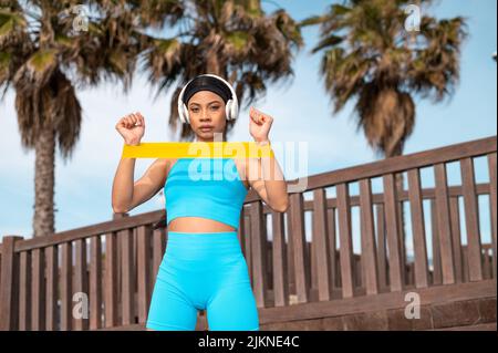 A pretty African American woman doing sports by the beach on a sunny day Stock Photo