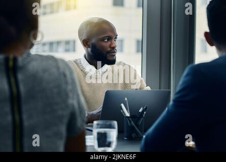 Were doing extremely well this quarter. a businessman using his laptop during a meeting. Stock Photo