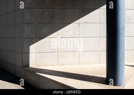 A photo of architecture details of modern concrete wall of a building with a pillar Stock Photo