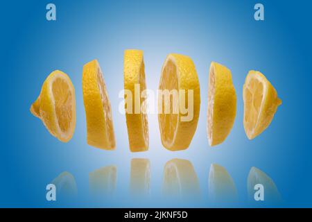 Floating slice of lemon in close-up macro on a blue background Stock Photo