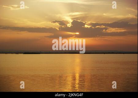 A scenic view of the orange evening sky reflected on a body of water Stock Photo