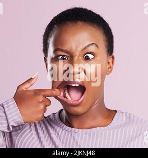 Why not just be weird. Studio shot of a young woman making a silly face against a pink background. Stock Photo