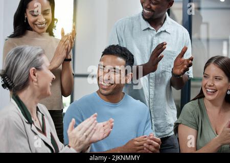 Excellence should never go unnoticed. a group of businesspeople applauding in an office. Stock Photo