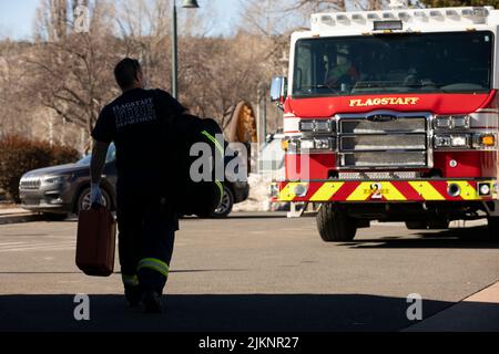 Flagstaff, Arizona, USA - January 7, 2022: A firefighter walks back to their firetruck with their paramedic supplies. Stock Photo