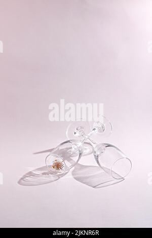 The two empty wine glasses and small cherry blossom isolated on a white background under the sunlight Stock Photo