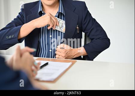 An Asian businessman in the meeting with his personal lawyer to pay a legal consultation fee. cropped image Stock Photo