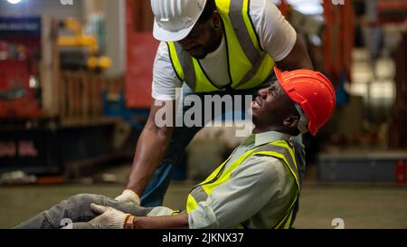 Accident concept , The team worker was born in a factory Accident. Being assisted by a team of safety, supervisors or foreman, Stock Photo