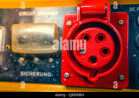 Power outlet with red grounding on the body of a gasoline electric generator close-up Stock Photo