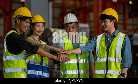 Teamwork and team spirit worker group give high five together corporate trust concept in Manufacturing Factory Team industry celebrate reward success Stock Photo