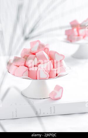 A vertical shot of pink marshmallows on the white background Stock Photo