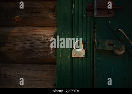 Rusty lock on the old wooden door. Front view. Stock Photo