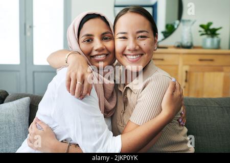 I couldnt do life without my best friend. two young women sitting on the sofa together at home and hugging. Stock Photo