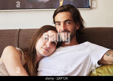 Were just having a lazy day. a young couple relaxing on the couch at home. Stock Photo