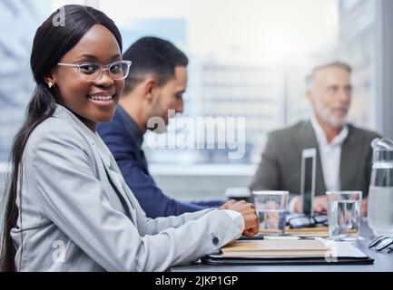 Were having some big discussions about success. Portrait of a young businesswoman having a meeting with her colleagues in a boardroom. Stock Photo