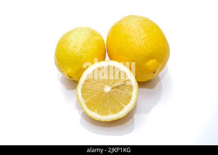 A closeup shot of ripe lemon and a half lemon on white background Stock Photo