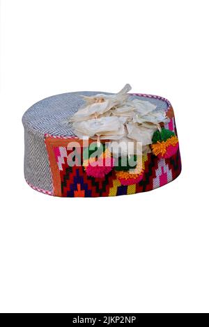 closeup the colorful hand made himachali indian traditional cap with hanging white flowers isolated on white background. Stock Photo
