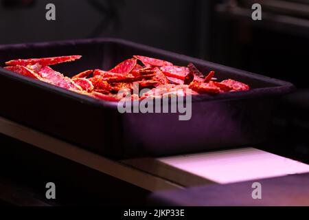 Iberian salami sliced with spices on a black plastic tray, traditional Spanish sausage, selective approach to salami. Stock Photo