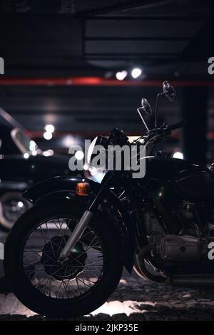 A closeup shot of a black Royal Enfield Classic 350 motorcycle in the garage at the night Stock Photo