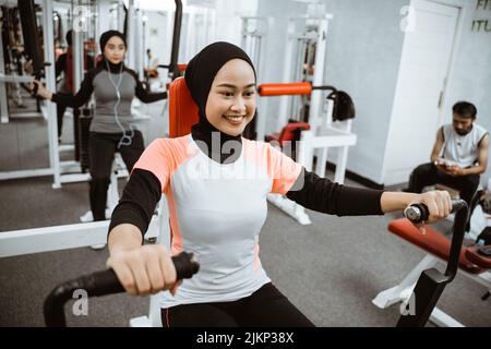 Young woman using a chest press machine - Stock Image - C047/0761 - Science  Photo Library