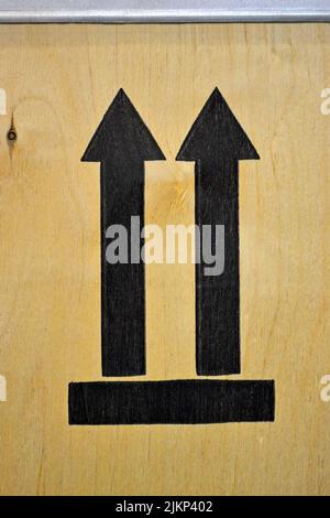 few black arrows on wooden veneer surface closeup, luggage orientation diversity Stock Photo