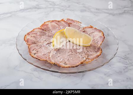 A view of Spanish food shredded meat with lemon on glass plate Stock Photo