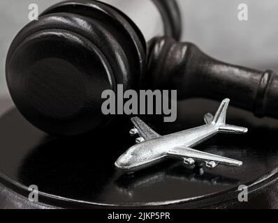 close up of judge gavel with silver airplane, concept of court decisions after flight cancellation and possible compensation claims Stock Photo