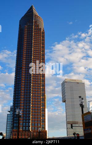 Wide-angle view of the Messeturm and the recently completed ONE tower at Messe Frankfurt, Germany. December 2021. Blue sky with clouds. Stock Photo