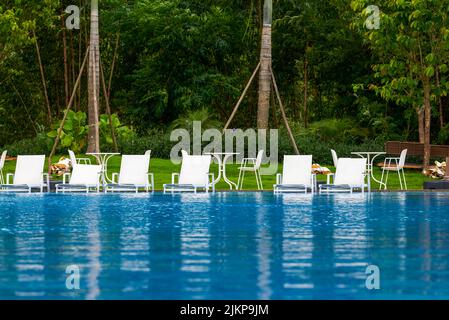 Infinity pool and lounge chairs in a luxury hotel Stock Photo