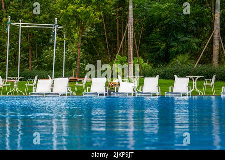 Infinity pool and lounge chairs in a luxury hotel Stock Photo