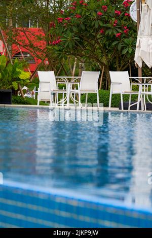 Infinity pool and lounge chairs in a luxury hotel Stock Photo
