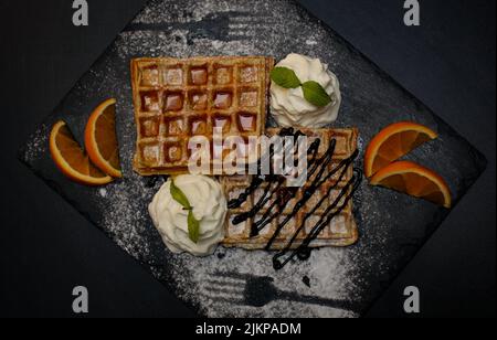 A top view of Belgium waffles with maple syrup ice cream and fruits Stock Photo