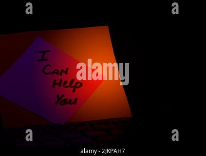 I can help you wrote on a card at the office Hold The Hand, Concept of I can help you written on a card. Stock Photo