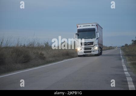 Big white truck with trailer in the little country road. Stock Photo