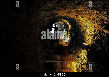 Silhouette at the narrow dark tunnel in Vardzia in Georgia Stock Photo