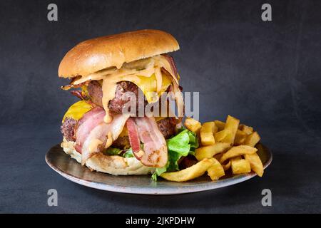 a close up shot of Bavarian burger with double beef and french fries on side in a plate. Stock Photo