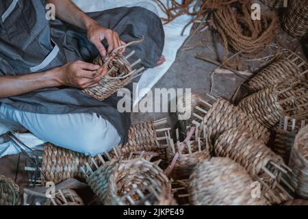 close up of the hands of craftsman weaving making souvenirs Stock Photo