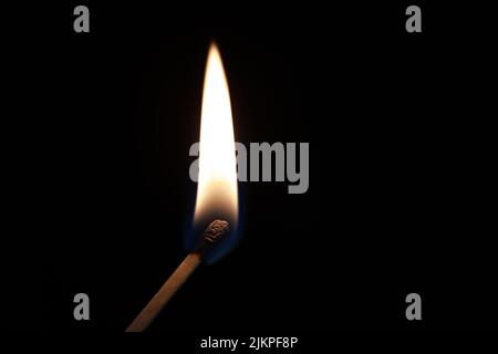 A closeup of a burning match stick on a black background with copyspace Stock Photo